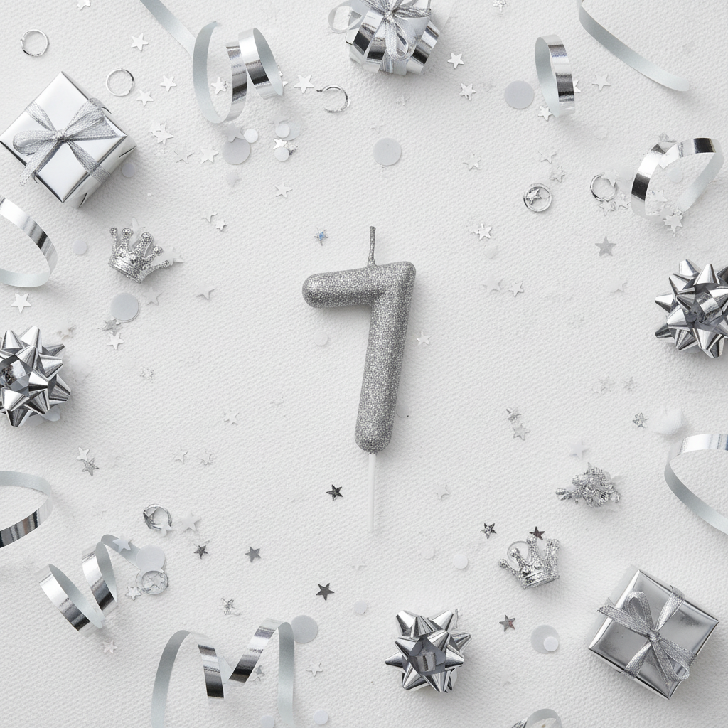 Silver glitter number 7 candle flat lay with silver ribbons gift boxes and silver party decor